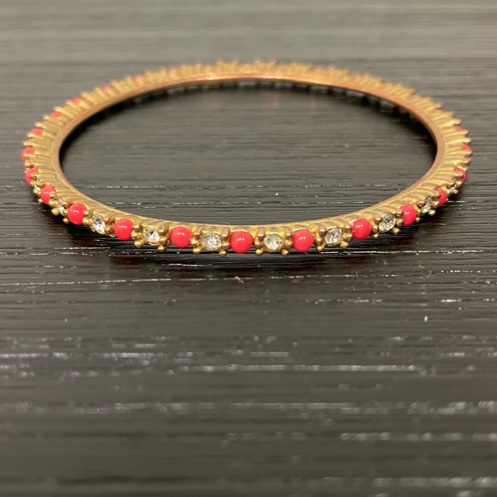 J. Crew gold bangle with red bead and fake diamond pattern